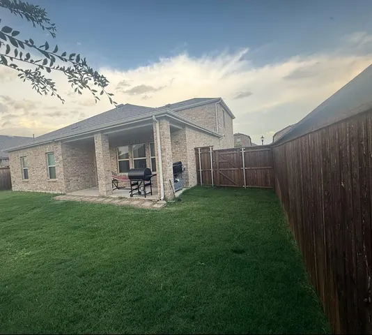 a backyard of a house with table and chairs