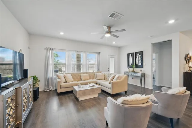 a living room with furniture a flat screen tv and a window