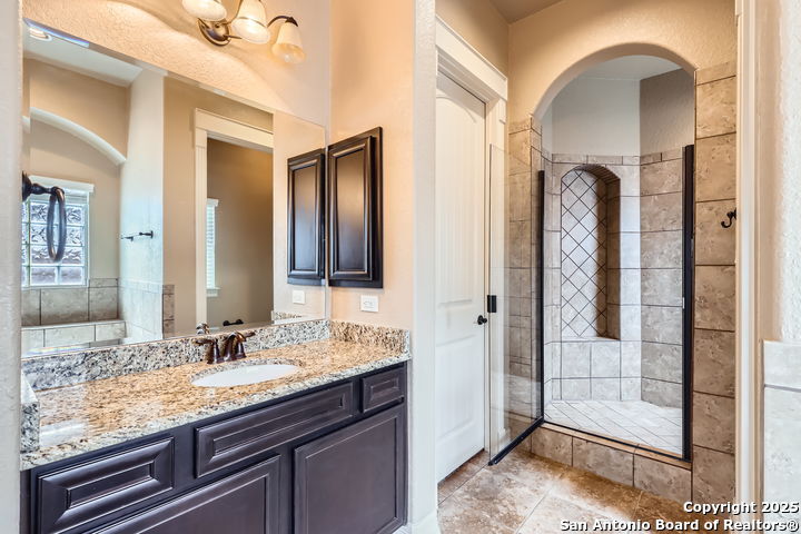 14722 Rifleman Road San Antonio, TX 78254 - Photo 19 of 37 a bathroom with a granite countertop sink and a mirror