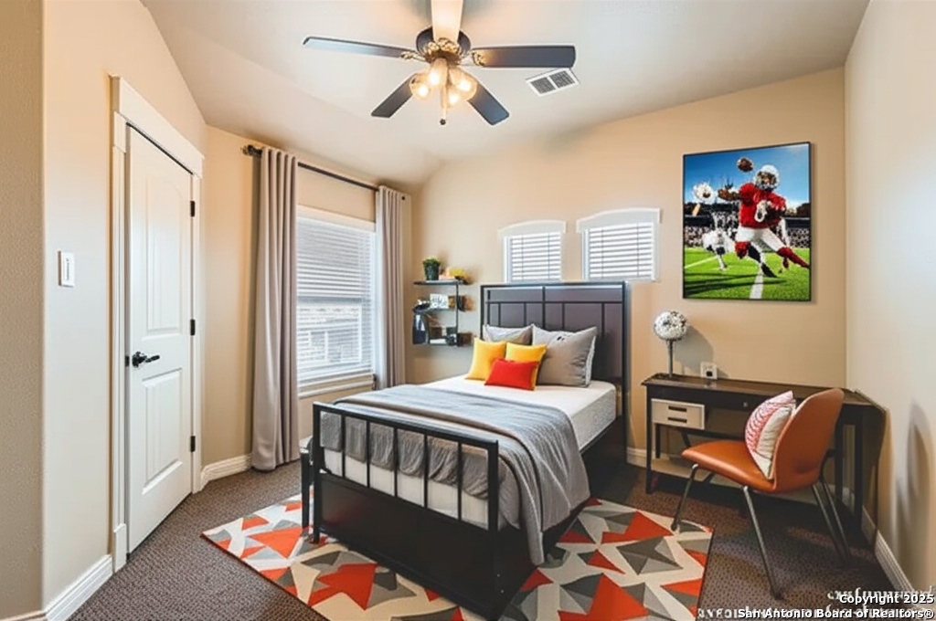 14722 Rifleman Road San Antonio, TX 78254 - Photo 29 of 37 a bedroom with a bed and a chandelier