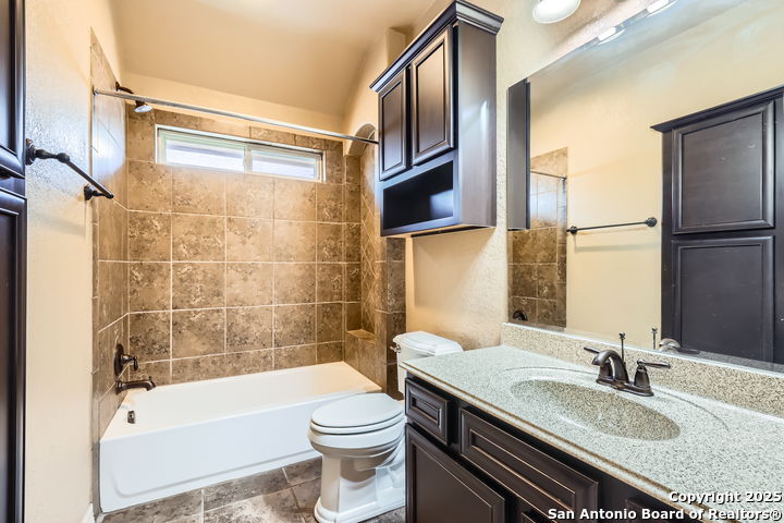 14722 Rifleman Road San Antonio, TX 78254 - Photo 31 of 37 a bathroom with a granite countertop sink toilet and shower