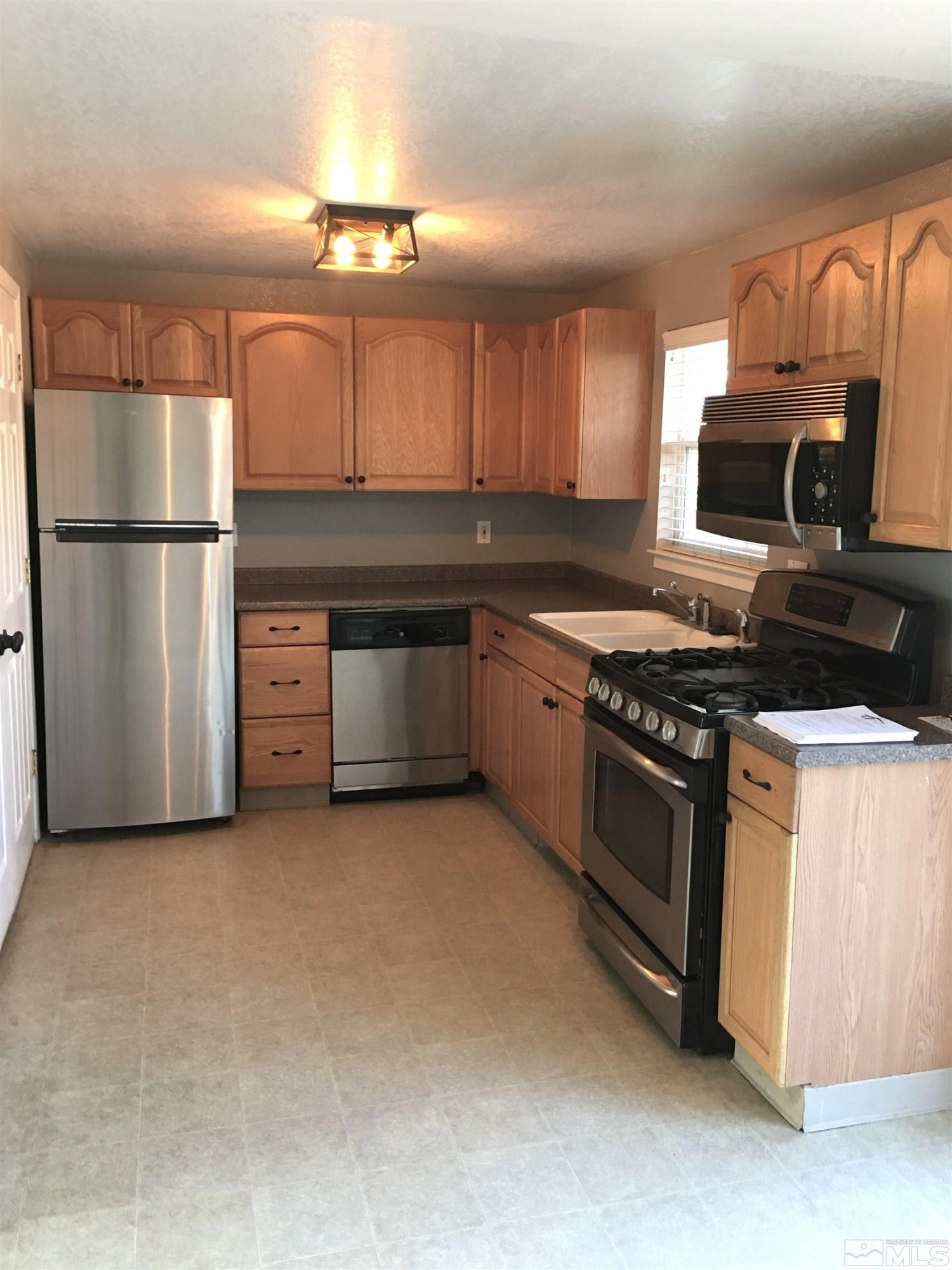 405 Kess Way Reno, NV 89506 - Photo 2 of 14 a kitchen with stainless steel appliances granite countertop a stove and a refrigerator