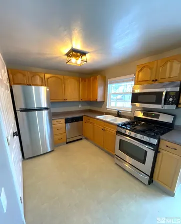 a kitchen with stainless steel appliances a stove a sink and a refrigerator