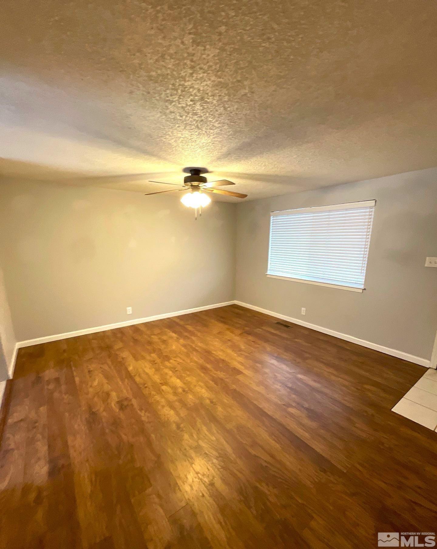 405 Kess Way Reno, NV 89506 - Photo 7 of 14 an empty room with wooden floor and windows