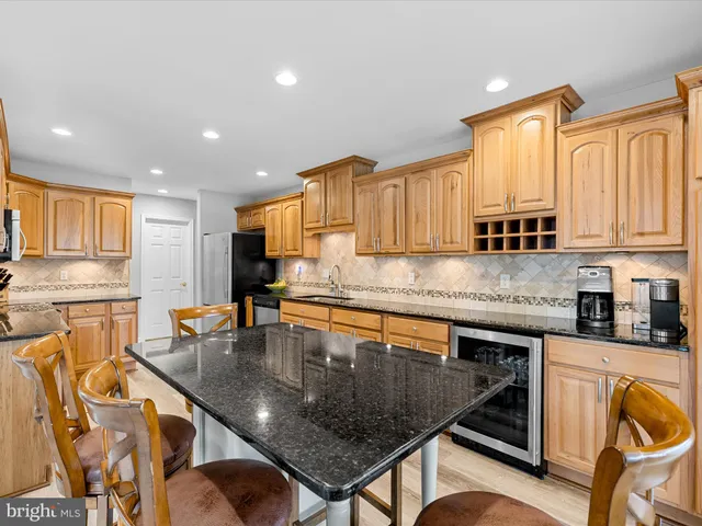 a kitchen with stainless steel appliances granite countertop a stove top oven a sink dishwasher and cabinets with wooden floor