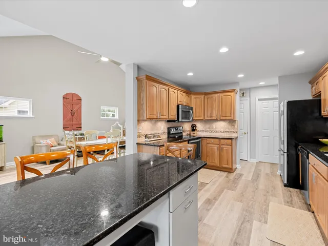 a kitchen with stainless steel appliances granite countertop a refrigerator stove top oven and sink