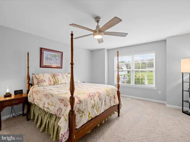 a bedroom with a bed a window and a chandelier
