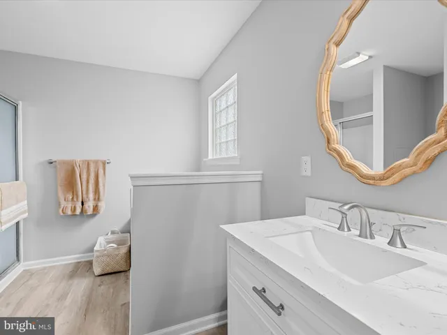 a en suite bathroom with a granite countertop sink and a mirror