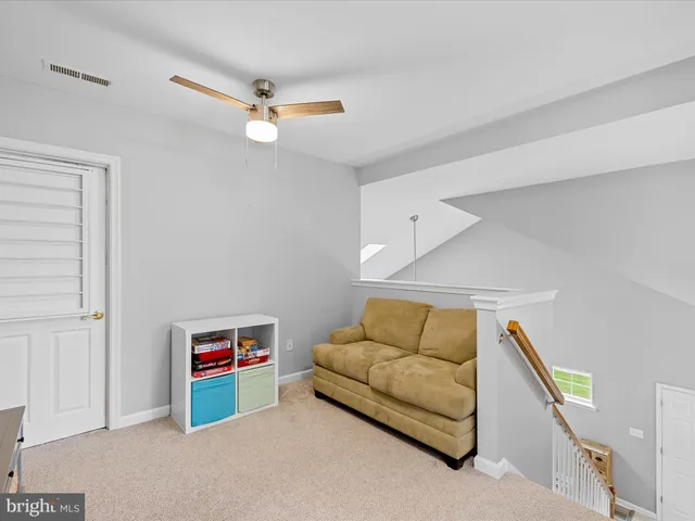 a living room with furniture and a ceiling fan
