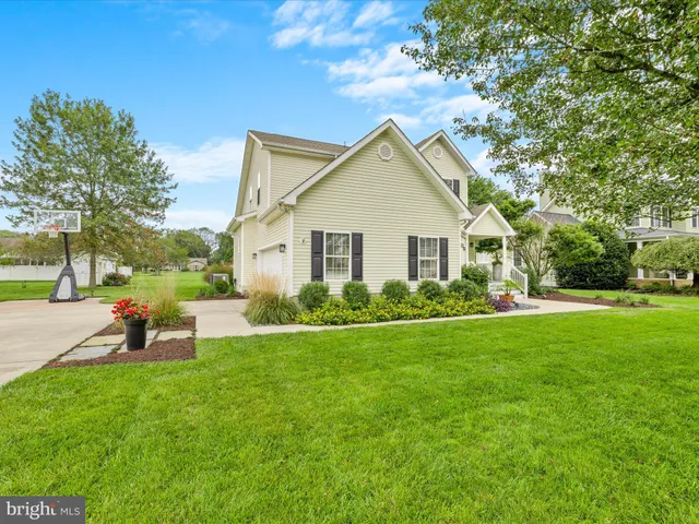 a view of a house with backyard and a tree