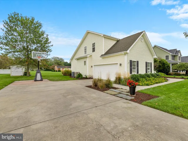 a view of a house with a yard and large tree
