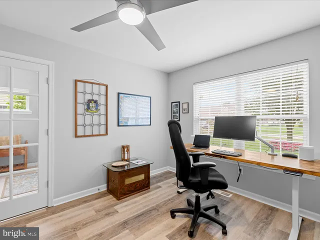 a view of a workspace with furniture and a window