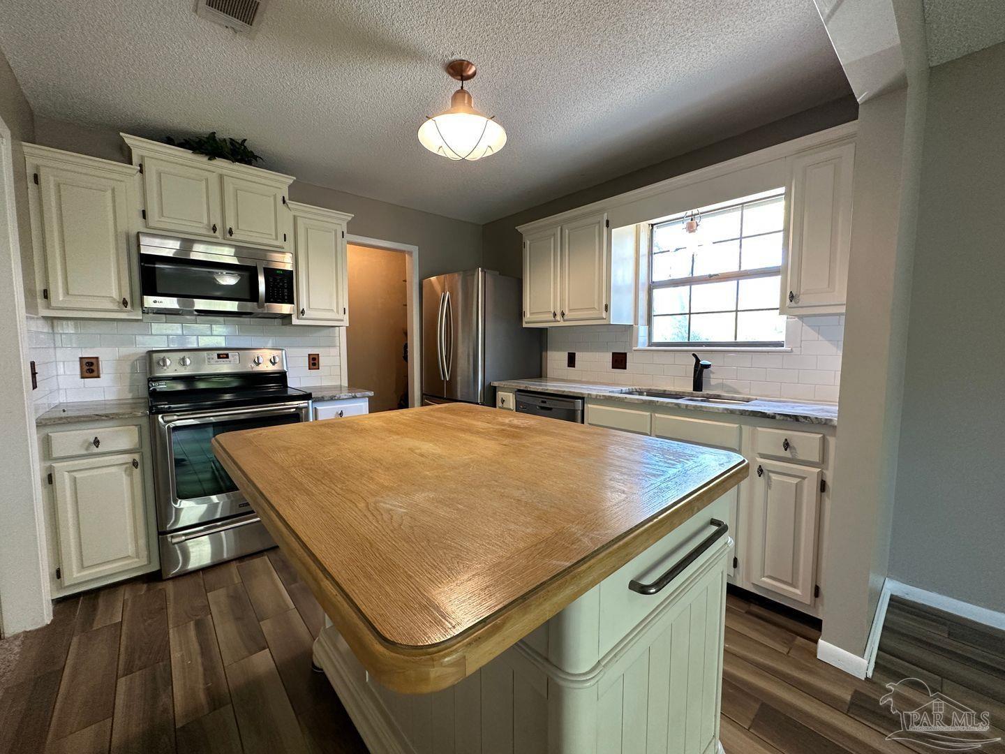 4831 East Olive Road, Unit 4D Pensacola, FL 32514 - Photo 4 of 17 a kitchen with stainless steel appliances a stove a sink and a microwave