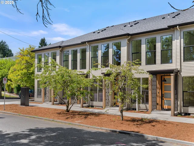 a front view of a house with a tree