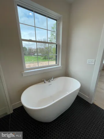 a white bath tub sitting in a bathroom next to a window
