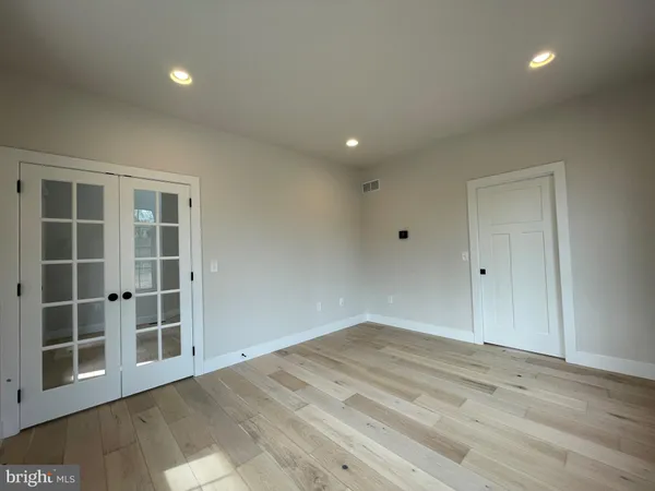 a view of empty room with wooden floor and windows