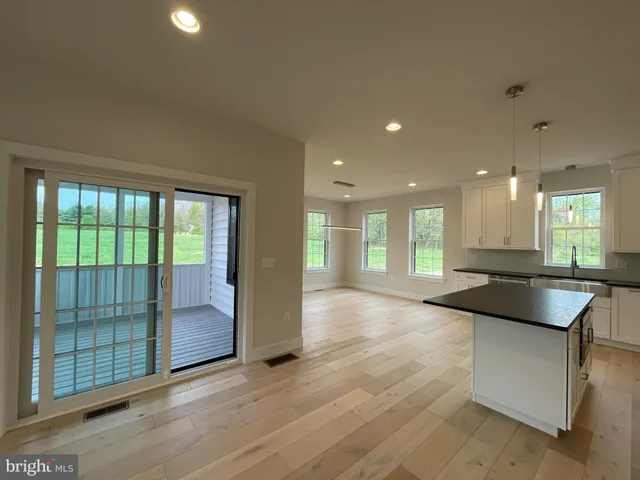 a kitchen with kitchen island granite countertop a sink and a stove top oven