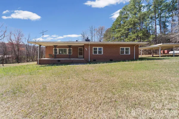 a view of a house with a yard and sitting area