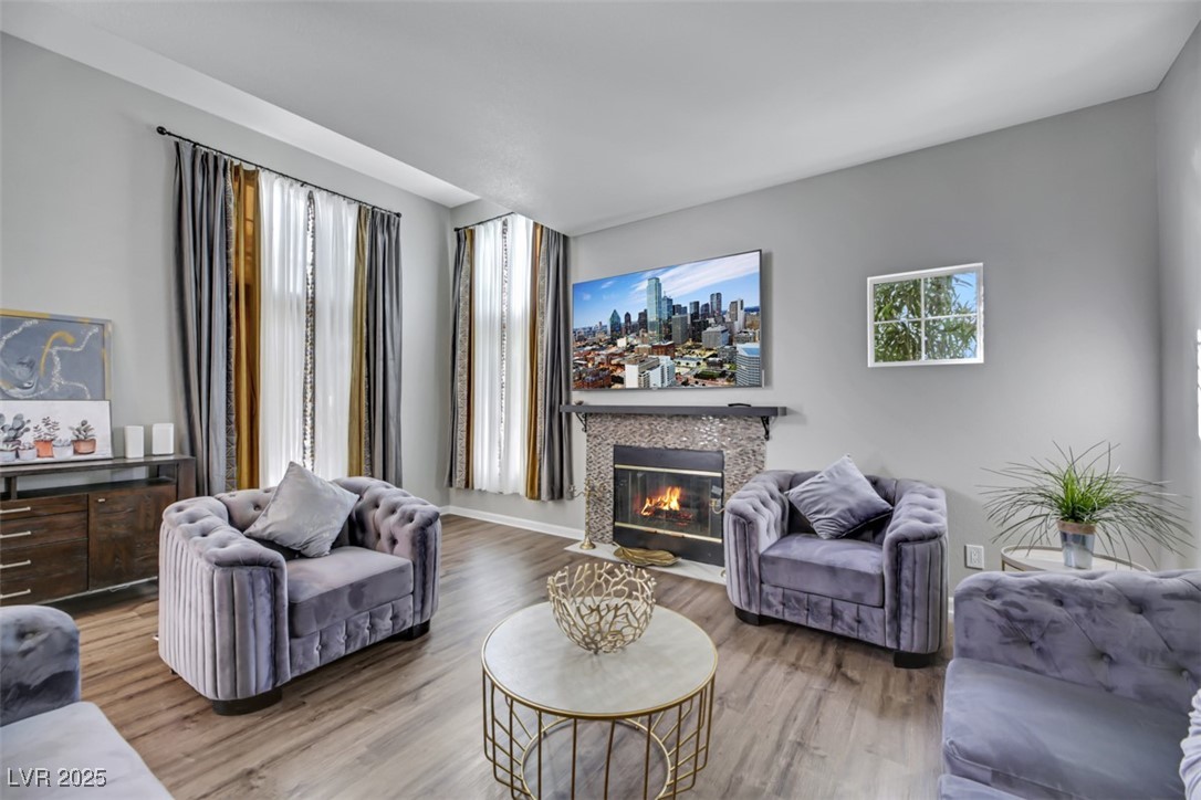 Living room with wood finished floors, plenty of natural light, and a fireplace