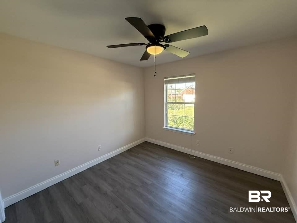 10428 South Side Loop Fairhope, AL 36532 - Photo 19 of 28 Unfurnished room with baseboards and dark wood-type flooring
