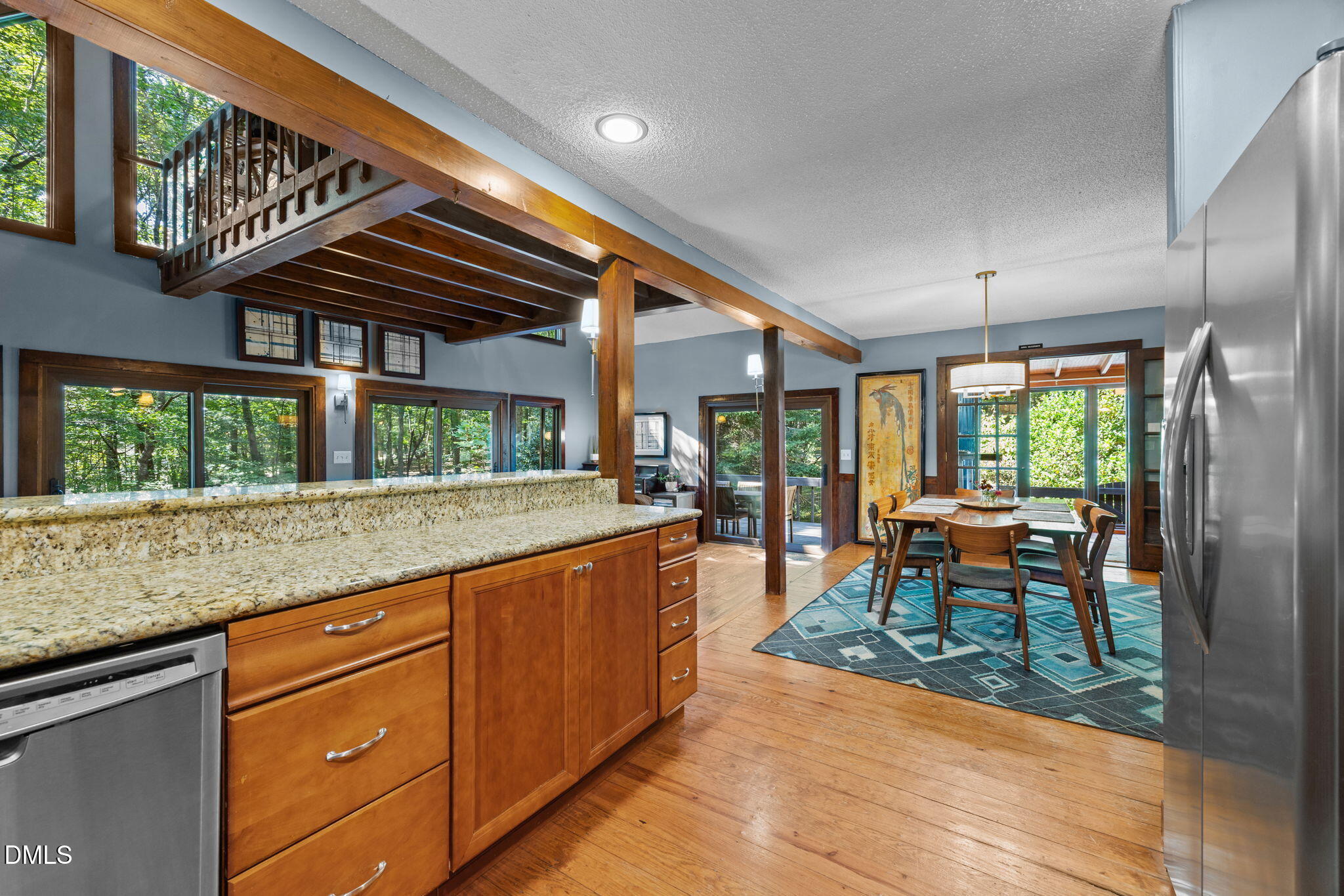 2408 Windsor Trail Raleigh, NC 27615 - Photo 13 of 45 a kitchen with granite countertop a stove a sink a dining table and chairs with wooden floor