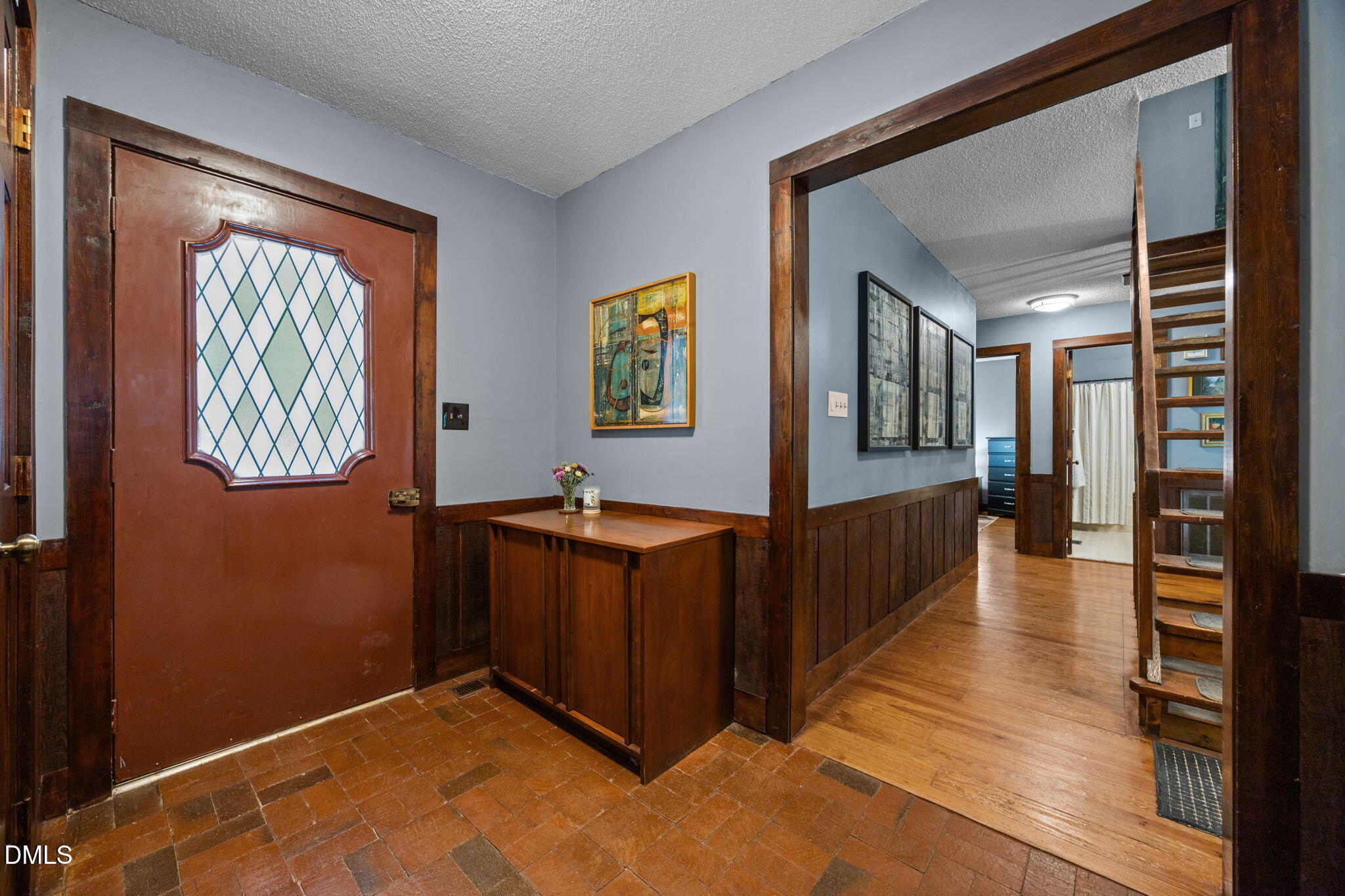 2408 Windsor Trail Raleigh, NC 27615 - Photo 6 of 45 a view of a hallway with wooden floor and a living room