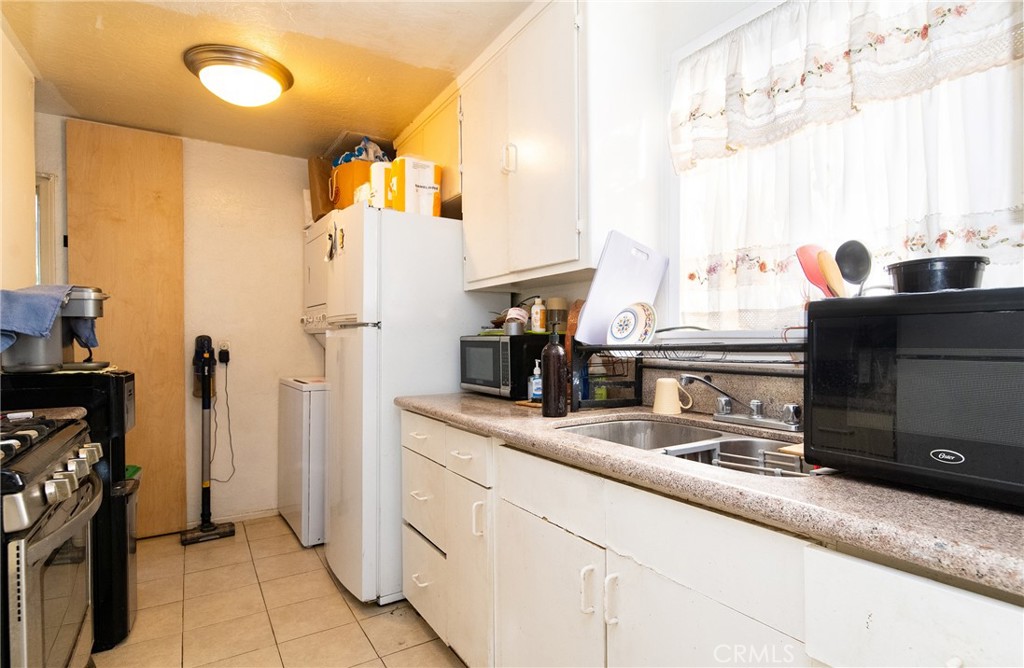 9814 Bandera Street Los Angeles, CA 90002 - Photo 12 of 15 a kitchen with a sink and a refrigerator