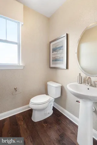 a bathroom with a toilet a sink and mirror