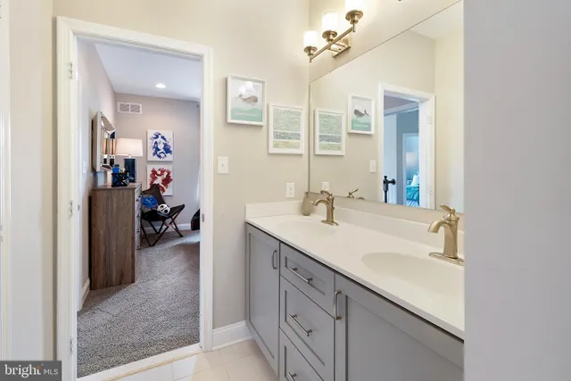 a en suite bathroom with a double vanity sink and a mirror