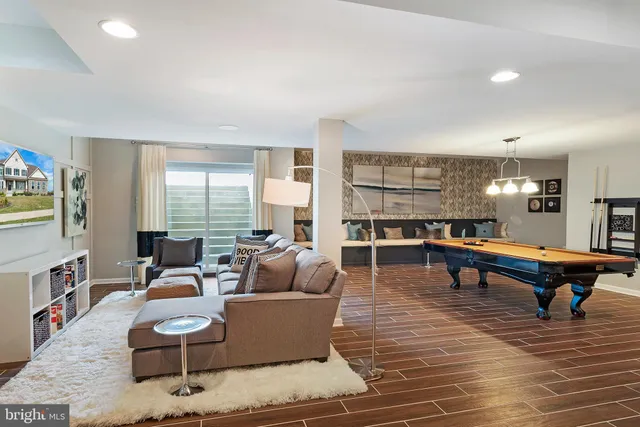 a living room with furniture a rug potted plant and a large window