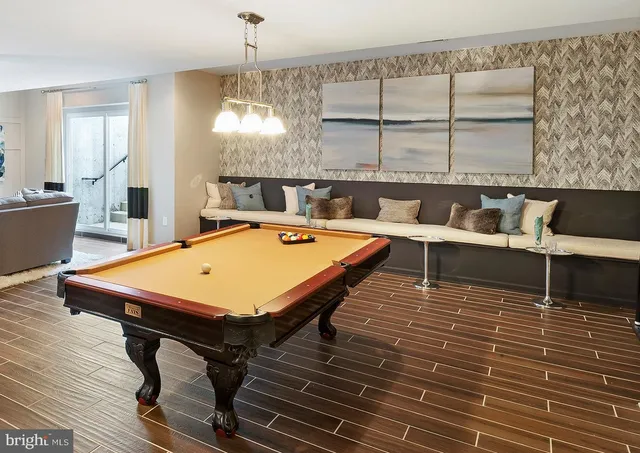 a room with wooden floor table and chairs