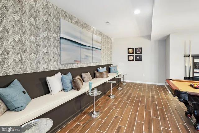 a living room with a couch and potted plant on the wall