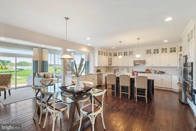 a view of a dining room and livingroom with furniture wooden floor a chandelier