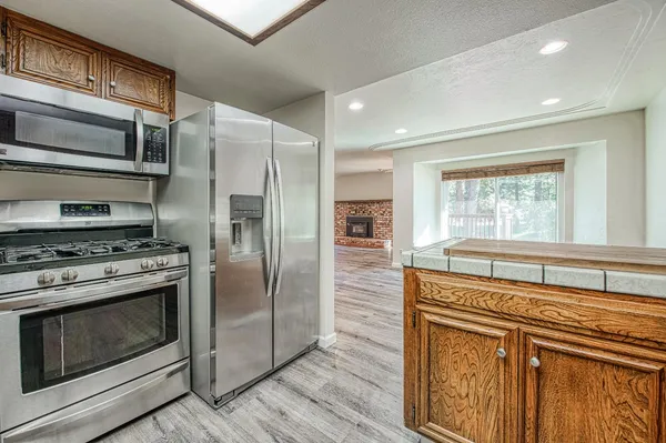 a kitchen with stainless steel appliances granite countertop a stove a refrigerator and a microwave