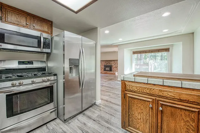 a kitchen with stainless steel appliances granite countertop a stove a refrigerator and a microwave