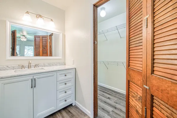 a bathroom with a granite countertop sink and a mirror