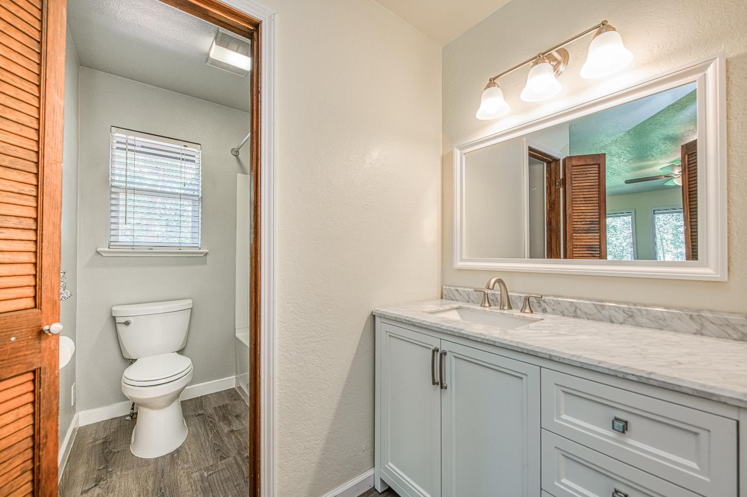 33988 Shaver Springs Road Auberry, CA 93602 - Photo 24 of 34 a bathroom with a toilet sink and mirror