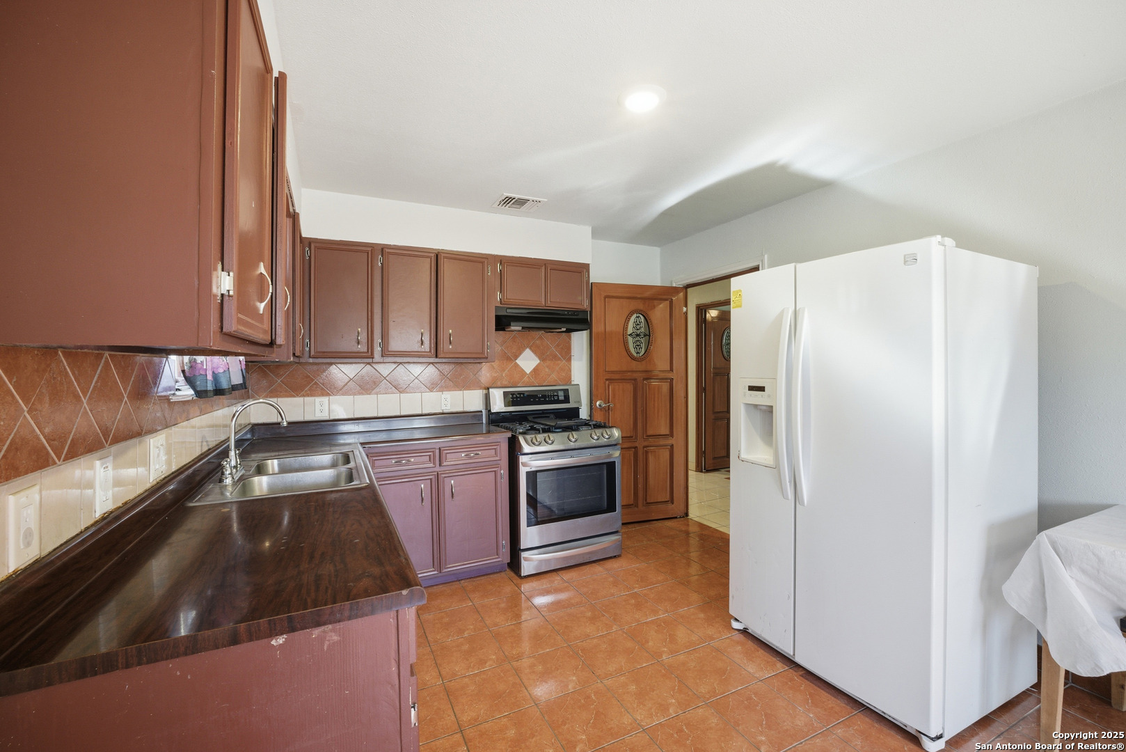 406 North Rancho Road Nixon, TX 78140 - Photo 11 of 31 a kitchen with granite countertop a refrigerator and a sink