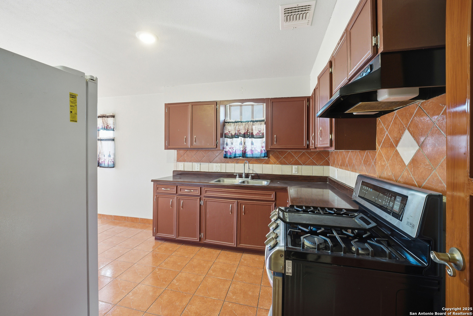 406 North Rancho Road Nixon, TX 78140 - Photo 12 of 31 a kitchen with stainless steel appliances granite countertop a stove and a sink