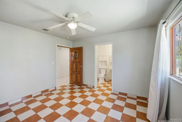 a view of a livingroom with a chandelier fan and windows