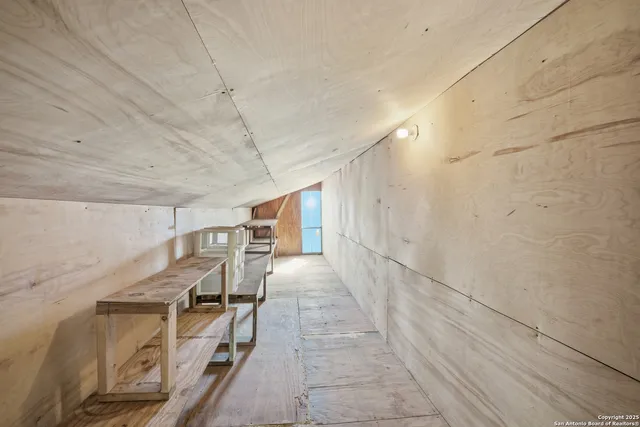 a view of empty room with kitchen and window