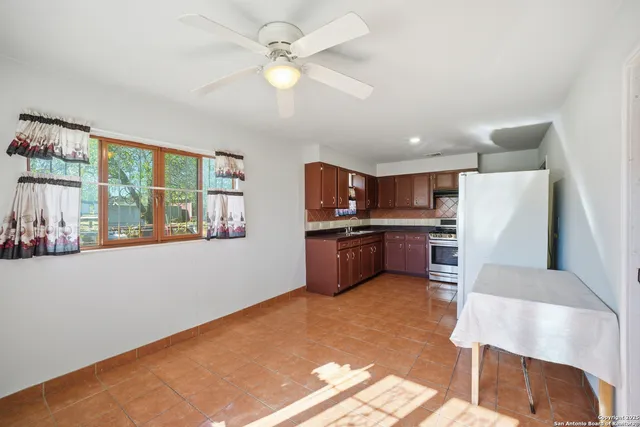 a kitchen with kitchen island a large counter top space a sink stainless steel appliances and cabinets