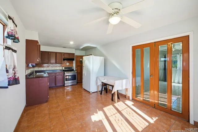 a open kitchen with stainless steel appliances granite countertop a refrigerator stove top oven and cabinets