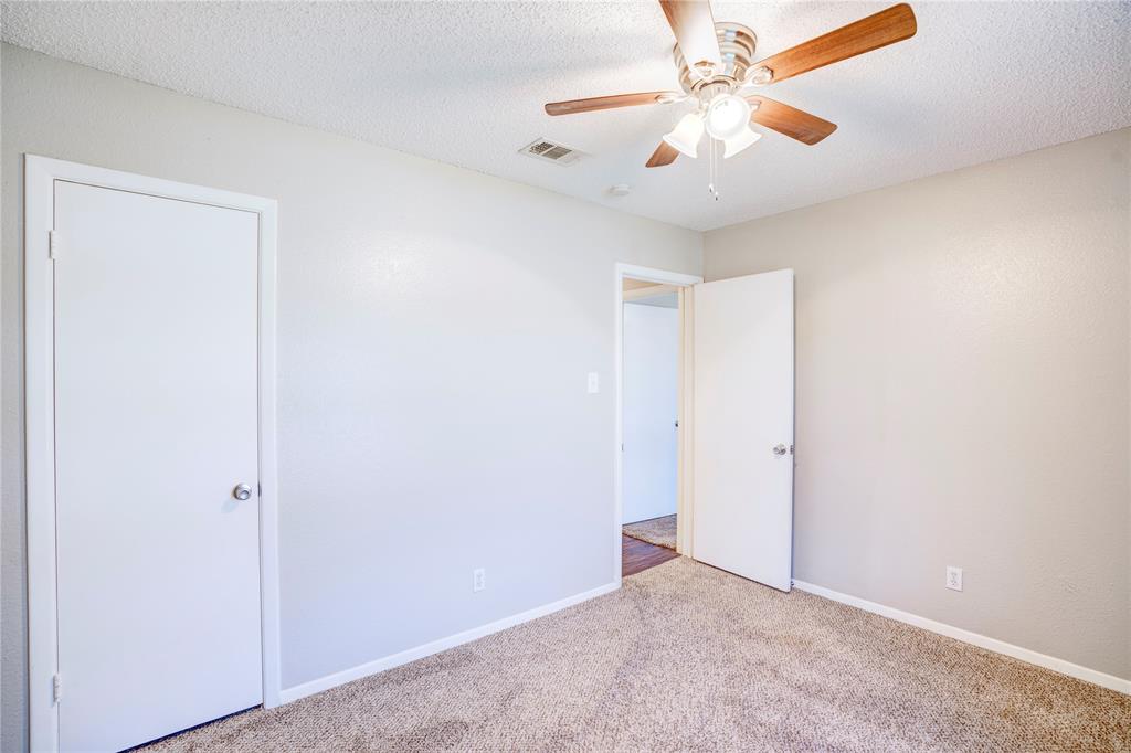 6028 Ridgecrest Drive Watauga, TX 76148 - Photo 31 of 40 an empty room with closet and a chandelier fan