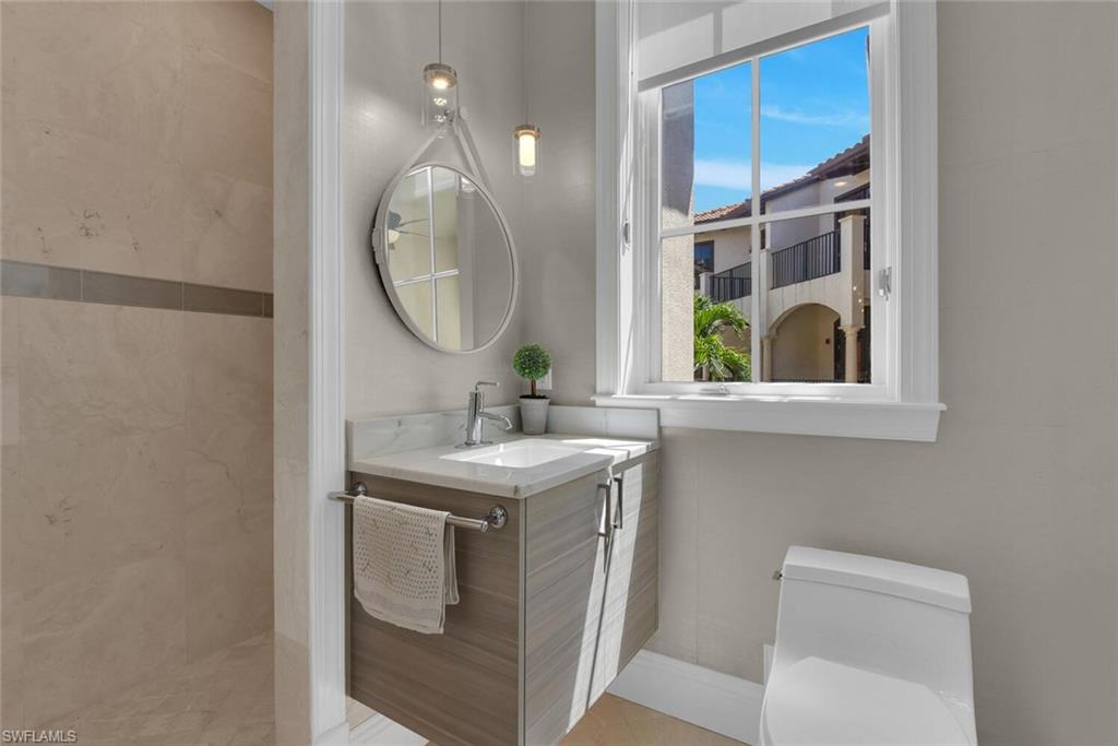 684 10th Avenue South, Unit D1 Naples, FL 34102 - Photo 14 of 45 a bathroom with a toilet sink and mirror
