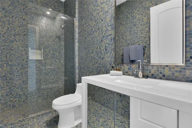 a bathroom with a sink a toilet and mirror