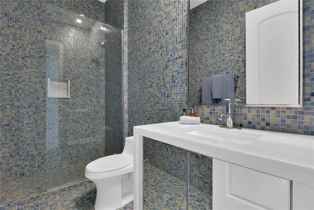 684 10th Avenue South, Unit D1 Naples, FL 34102 - Photo 28 of 45 a bathroom with a sink a toilet and mirror