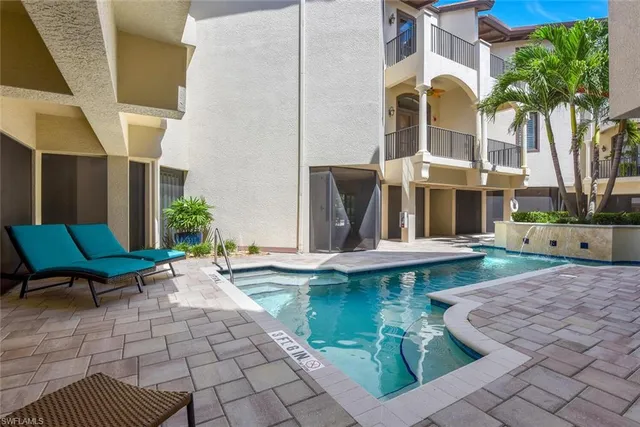 a view of pool with lawn chairs and floor to ceiling window