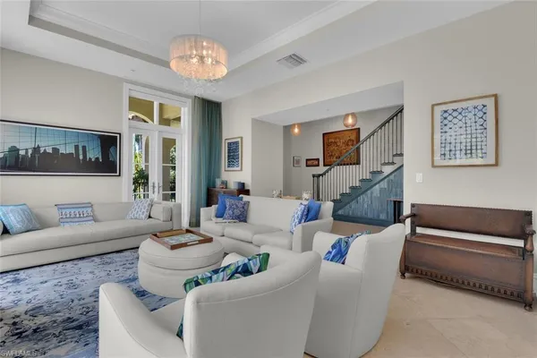 a living room with furniture and a chandelier