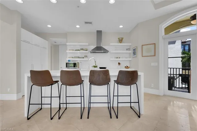 a kitchen with cabinets and chairs